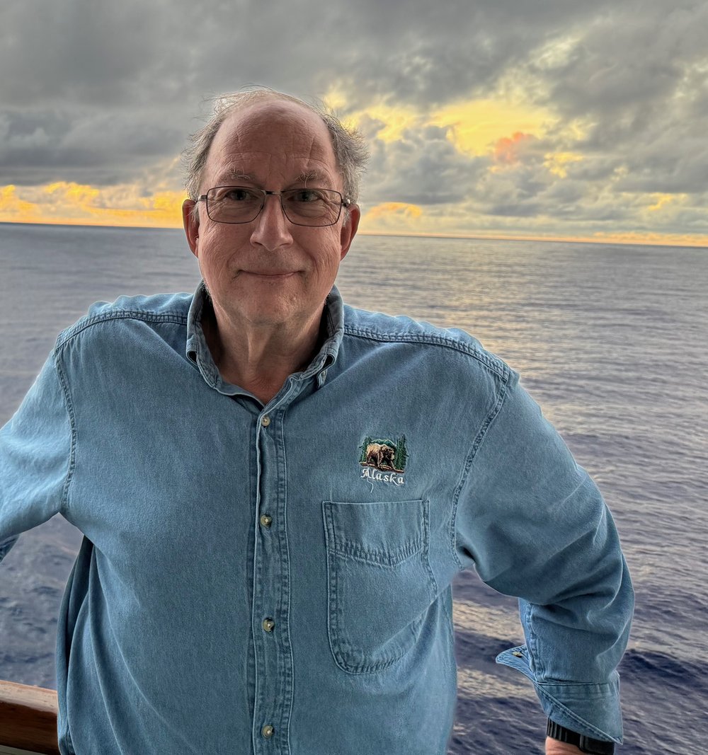 Dennis Weinstein on a ship's deck at sunset